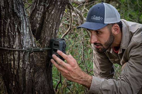 Graduate student, Jason Lombardi, checks a trap camera for the ocelot monitoring project.